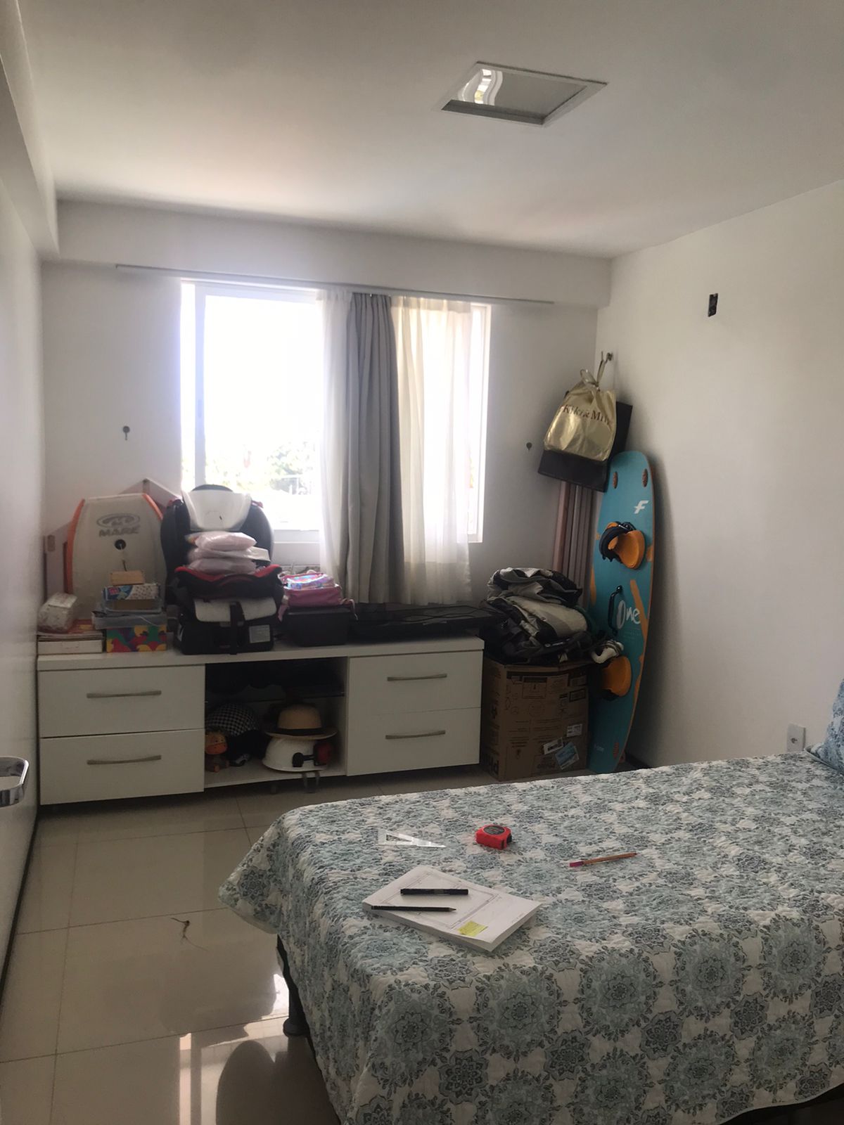 Antes: quarto da Juju com janela, cortina simples e bancada branca cheia de caixas