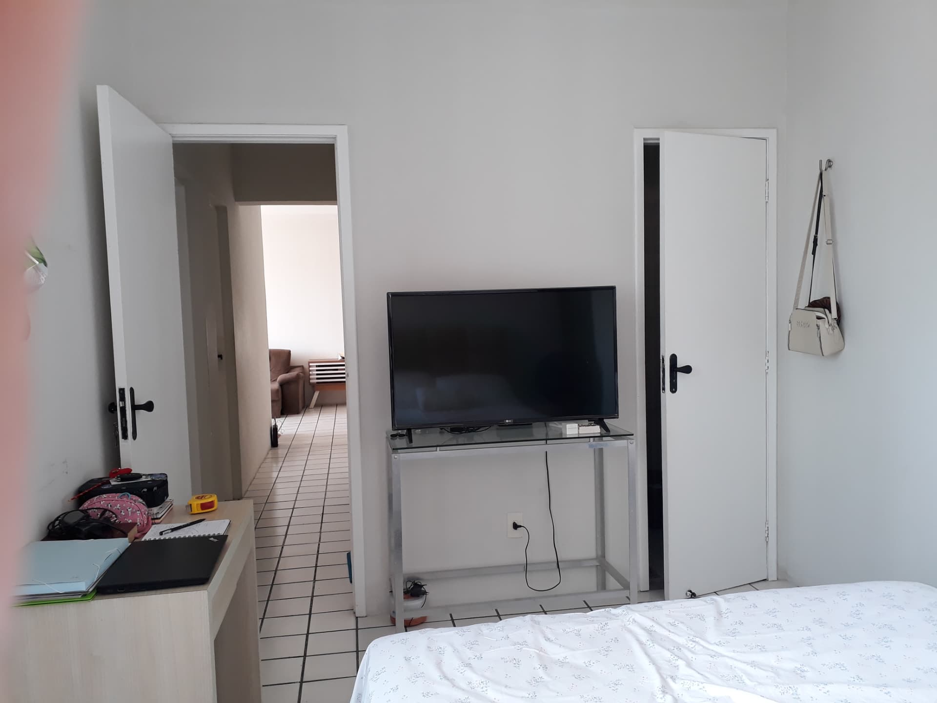Antes: parede das portas com TV apoiada em mesa de vidro